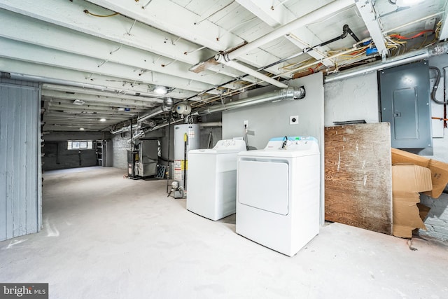 basement with heating unit, electric panel, washer and clothes dryer, and water heater