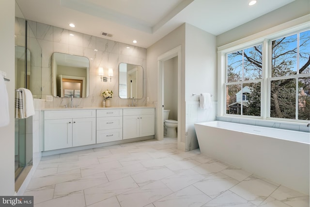 full bathroom featuring plus walk in shower, vanity, toilet, and tile walls