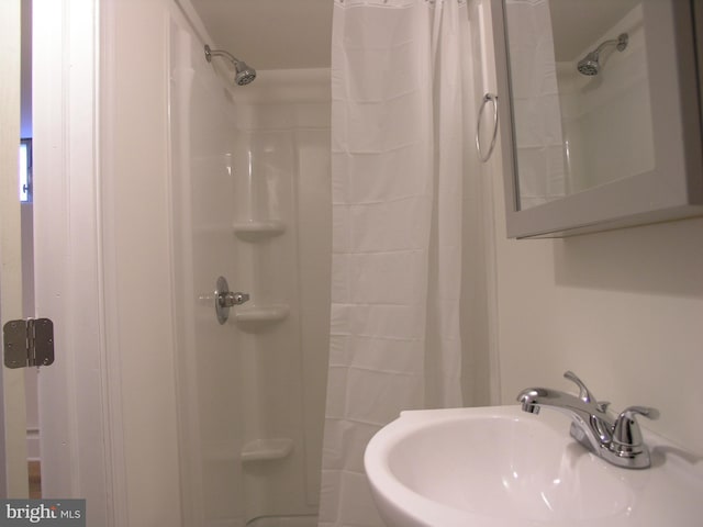 bathroom with a shower with shower curtain and sink