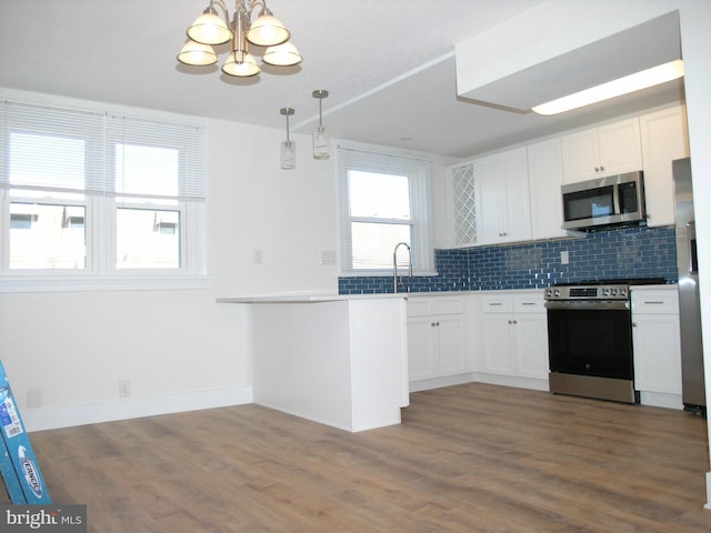 kitchen featuring white cabinets, hanging light fixtures, dark hardwood / wood-style floors, and appliances with stainless steel finishes