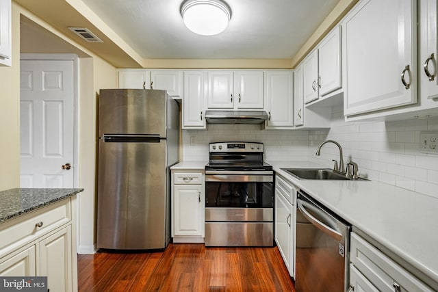 kitchen featuring appliances with stainless steel finishes, white cabinetry, dark wood-type flooring, and sink