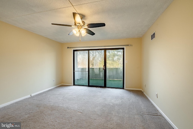 carpeted spare room with ceiling fan and a textured ceiling