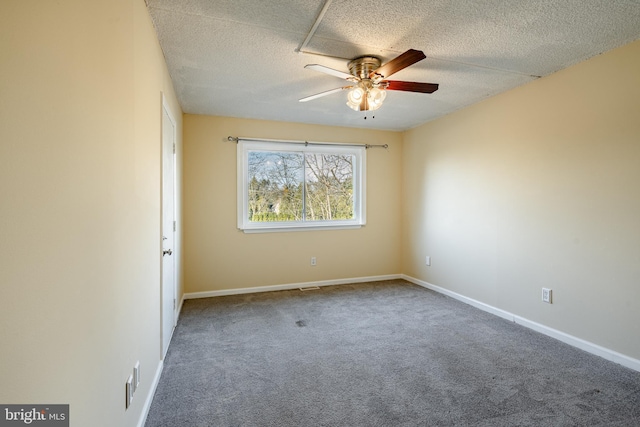 spare room featuring a textured ceiling, carpet floors, and ceiling fan