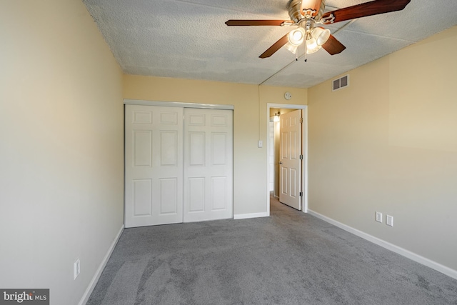 unfurnished bedroom with ceiling fan, carpet floors, a textured ceiling, and a closet