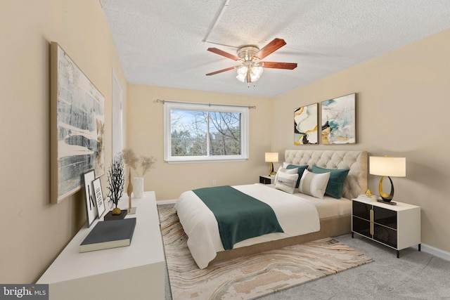 carpeted bedroom with ceiling fan and a textured ceiling