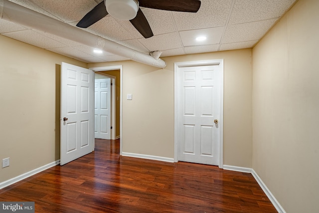 interior space featuring a paneled ceiling, ceiling fan, and dark hardwood / wood-style flooring