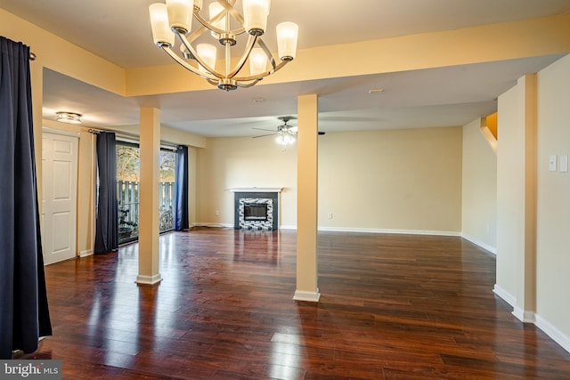 unfurnished living room featuring ceiling fan with notable chandelier and dark wood-type flooring