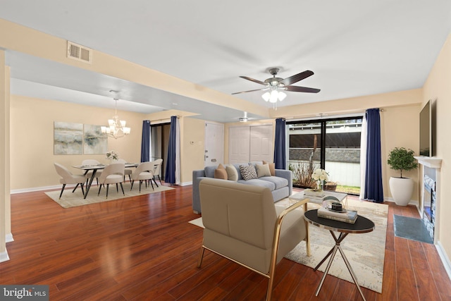 living room with hardwood / wood-style floors and ceiling fan with notable chandelier