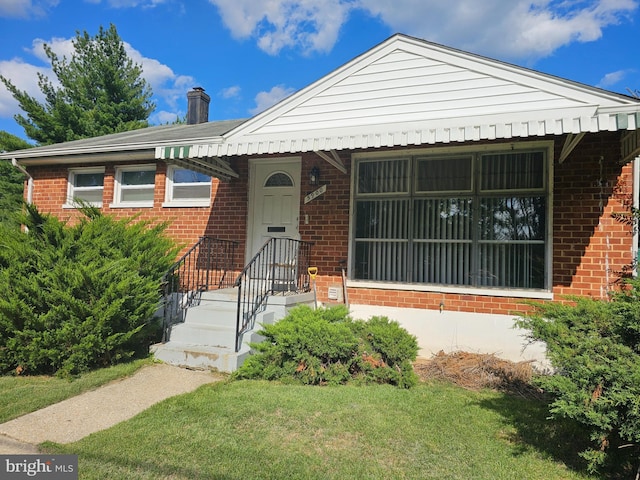 bungalow-style home featuring a front lawn