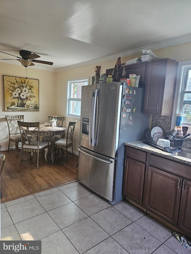 kitchen with stainless steel fridge, dark brown cabinetry, light hardwood / wood-style floors, and crown molding