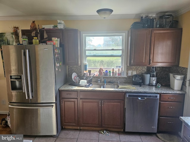 kitchen featuring crown molding, sink, tasteful backsplash, light tile patterned flooring, and stainless steel appliances