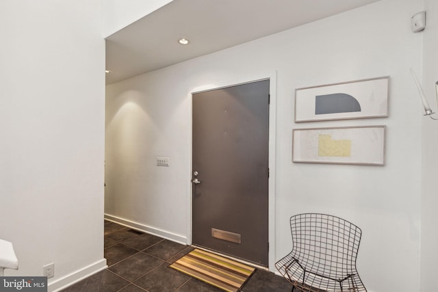 entryway with dark tile patterned flooring