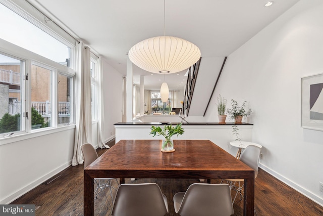 dining area featuring a healthy amount of sunlight and dark hardwood / wood-style flooring