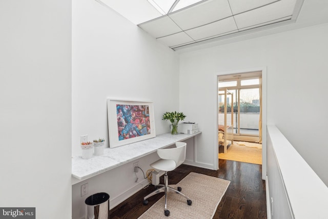 office area with dark hardwood / wood-style floors and built in desk