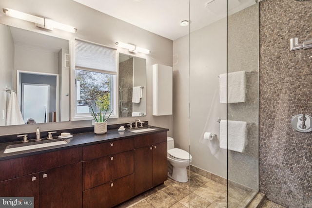 bathroom featuring tiled shower, vanity, and toilet