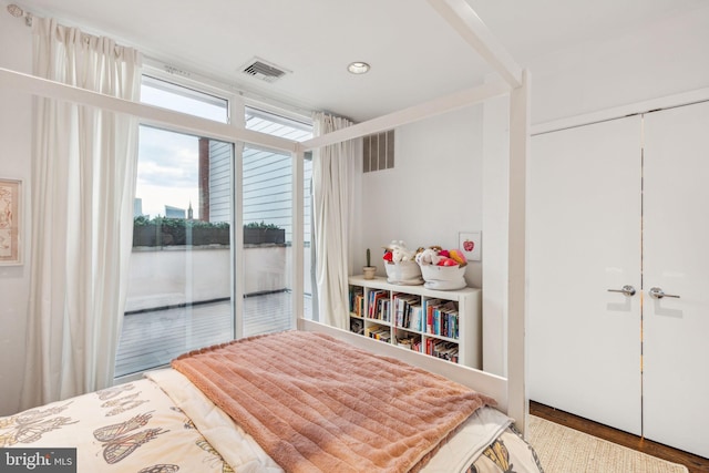 bedroom featuring wood-type flooring, access to outside, and a closet