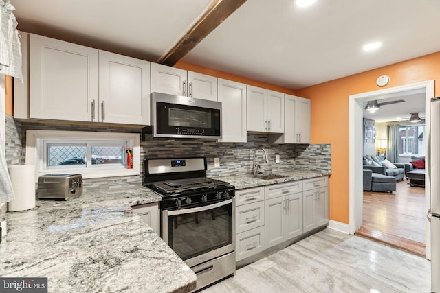 kitchen with sink, stainless steel appliances, tasteful backsplash, light hardwood / wood-style flooring, and beamed ceiling