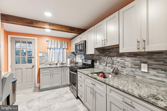 kitchen with sink, tasteful backsplash, beamed ceiling, light stone counters, and stainless steel appliances