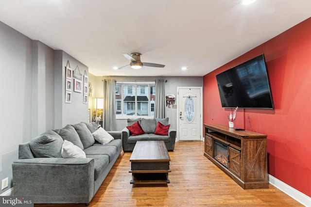 living room featuring ceiling fan and light hardwood / wood-style flooring