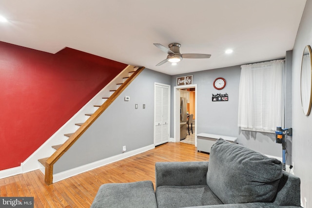 living area featuring hardwood / wood-style floors and ceiling fan