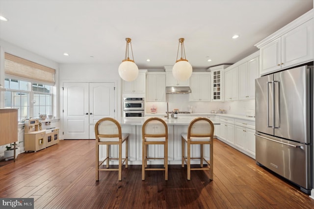 kitchen with white cabinets, decorative light fixtures, dark wood-type flooring, and appliances with stainless steel finishes