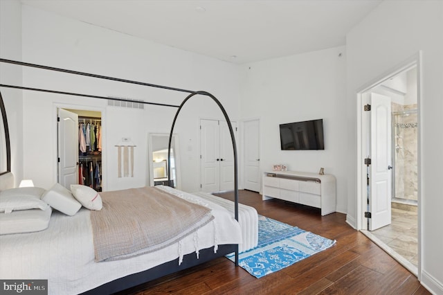 bedroom with dark hardwood / wood-style flooring, a spacious closet, and a closet