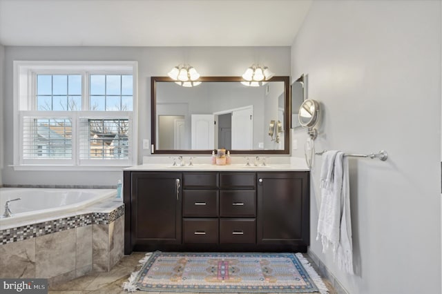 bathroom with tiled tub and vanity