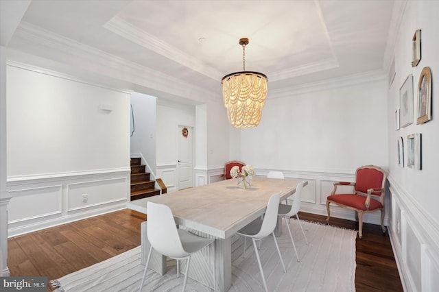 dining room featuring a tray ceiling, crown molding, a chandelier, and hardwood / wood-style flooring