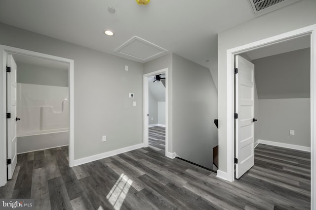 unfurnished bedroom featuring ensuite bathroom and dark hardwood / wood-style floors