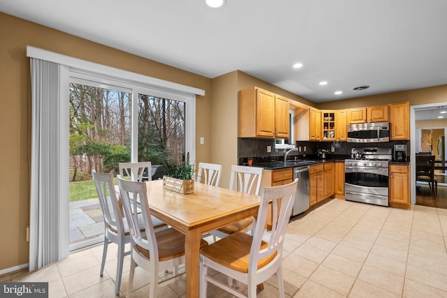 kitchen with stainless steel appliances, sink, light tile patterned floors, and decorative backsplash