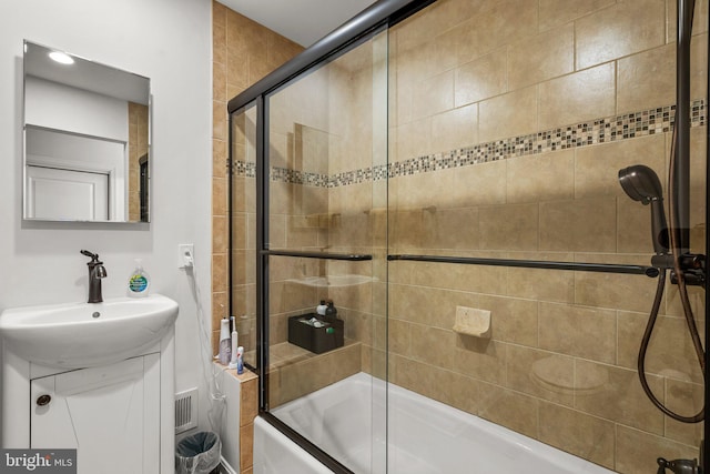 bathroom with sink and shower / bath combination with glass door