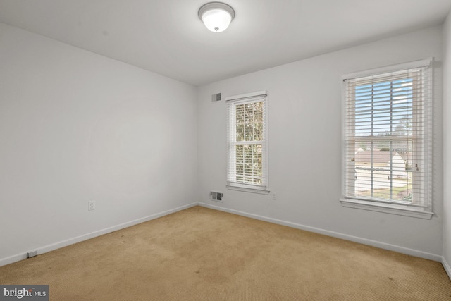 empty room with a wealth of natural light and light colored carpet