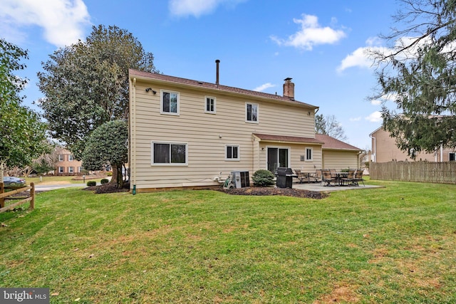 rear view of property with a yard and a patio area