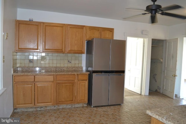 kitchen with ceiling fan, stainless steel fridge, and backsplash