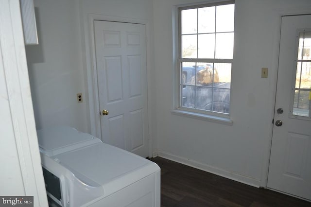 clothes washing area with dark hardwood / wood-style flooring, washer and clothes dryer, and a healthy amount of sunlight