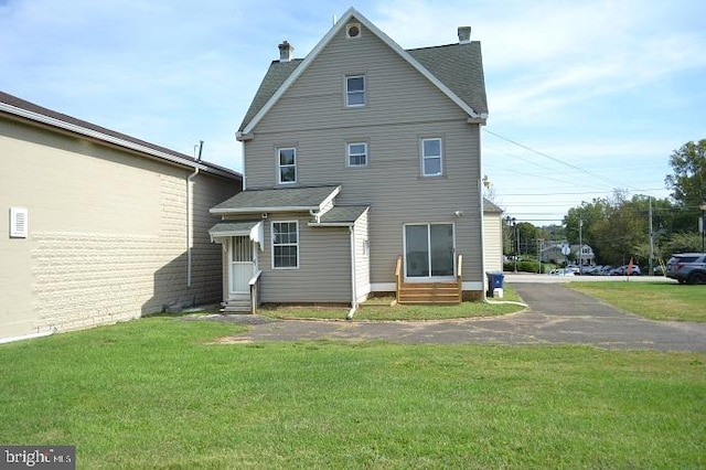 back of property featuring a yard