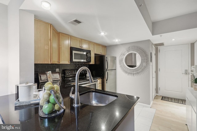 kitchen featuring light brown cabinets, stainless steel appliances, backsplash, kitchen peninsula, and light hardwood / wood-style floors