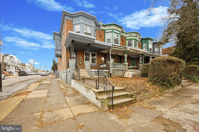 multi unit property featuring brick siding and a porch