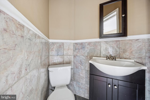 half bath featuring wainscoting, vanity, and toilet