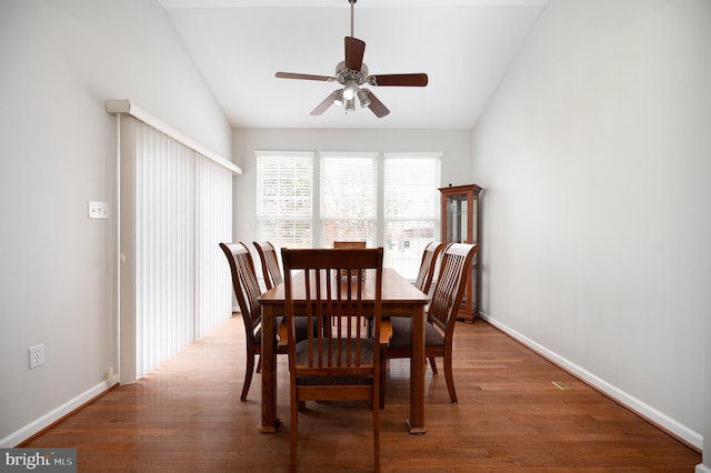 dining room with ceiling fan, dark hardwood / wood-style floors, and lofted ceiling