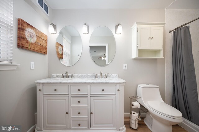 bathroom with a shower with curtain, ceiling fan, vanity, and toilet