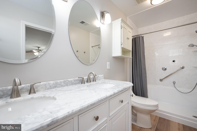 bathroom with a shower with shower curtain, vanity, ceiling fan, hardwood / wood-style flooring, and toilet