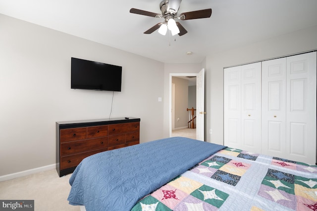 carpeted bedroom featuring ceiling fan and a closet