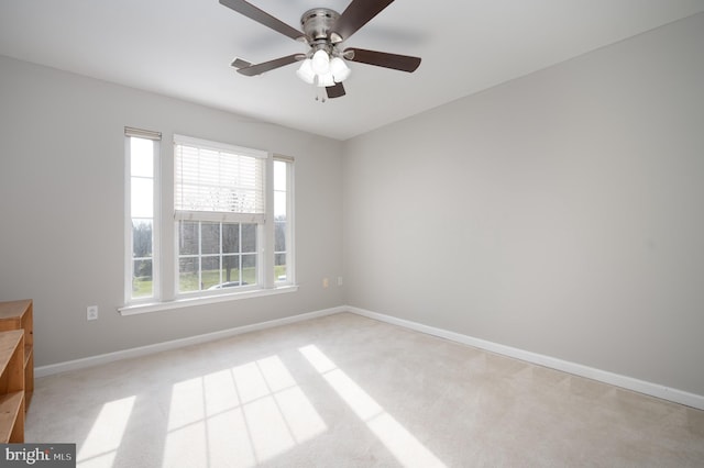 unfurnished room with light carpet, a wealth of natural light, and ceiling fan