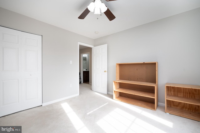 unfurnished bedroom with ceiling fan, light colored carpet, and a closet