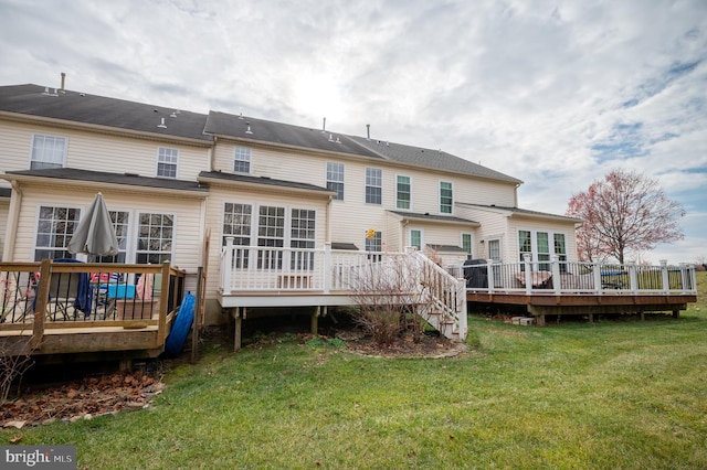 back of house featuring a lawn and a deck