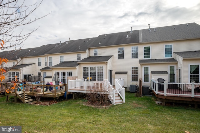 rear view of property featuring a yard, cooling unit, and a wooden deck