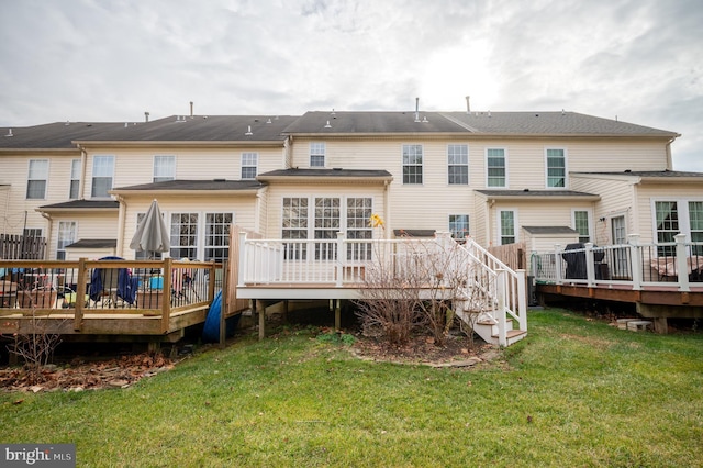 back of property featuring a deck and a yard