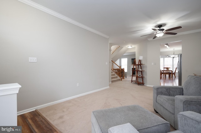 living room featuring ceiling fan with notable chandelier, light hardwood / wood-style flooring, and ornamental molding