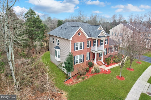 view of front of home with a balcony and a front yard